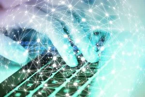 Une main écrit au clavier d'un ordinateur, entourés d'une toile réseau. Illustre la phase rédactionnelle de l'élaboration des plans, guidée par Conformity Data