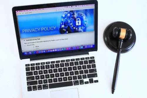 Un laptop ; à l'écran un cadenas et les mots Privacy Policy. Un maillet de juge rappelle la règlementation et les missions du DPO